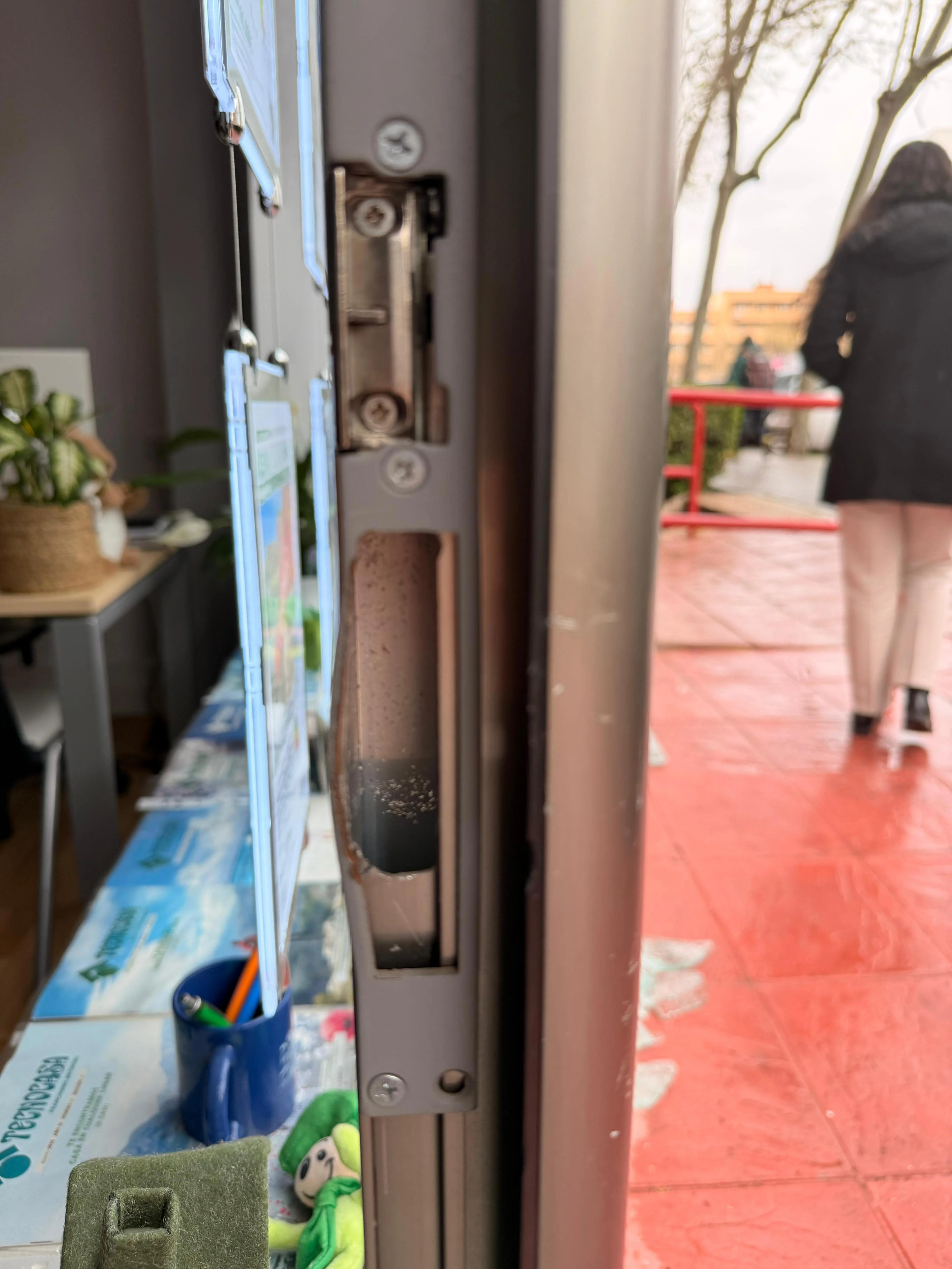 Antes: detalle del marco de la puerta con el cerradero doblado y el metal deformado